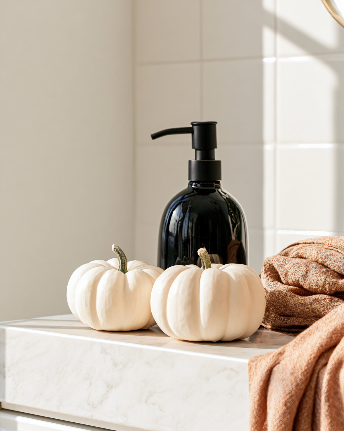 A variety dark and clear bottles with oils, a wood spoon, two brushes, and a bar of soap